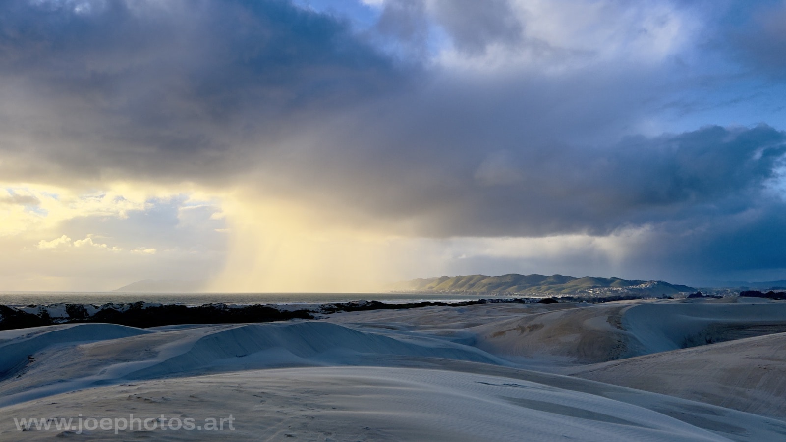 Sand dunes and storm at sunset