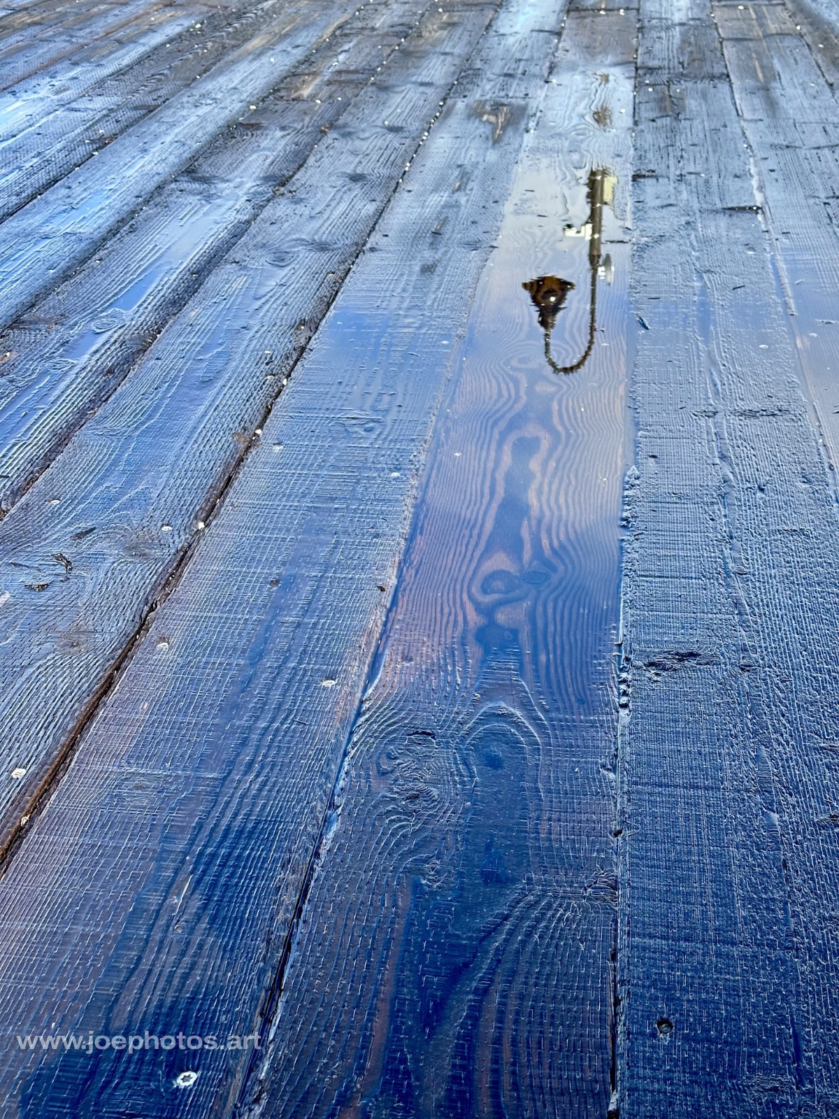 Reflective rain puddle on wood.