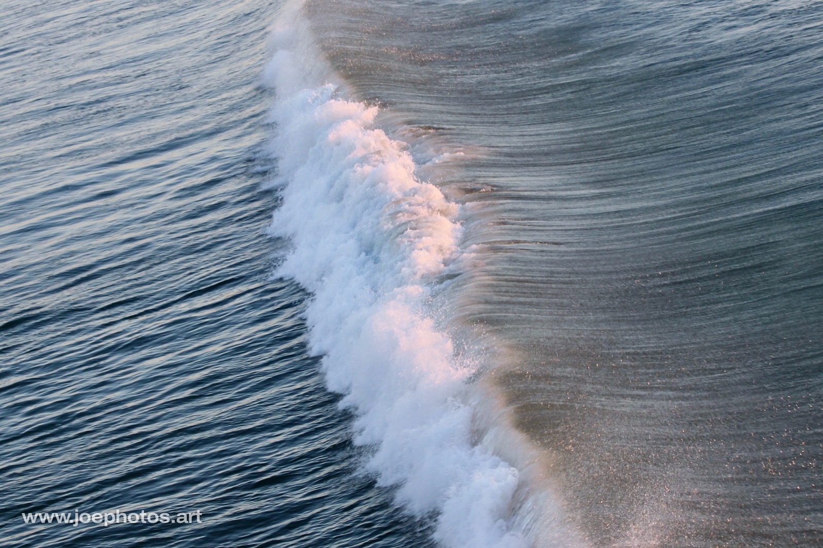Crashing sculpted ocean waves at sunrise.