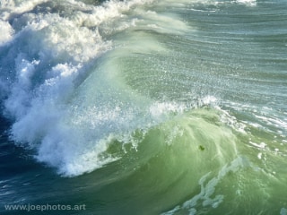 backlit ocean waves approaching sunset