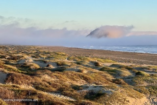 morro rock and beach with marine layer at sunset