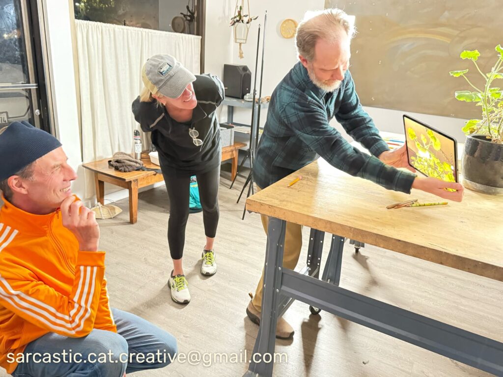 Joe demonstrates photo composition techniques with an iPad for two students.